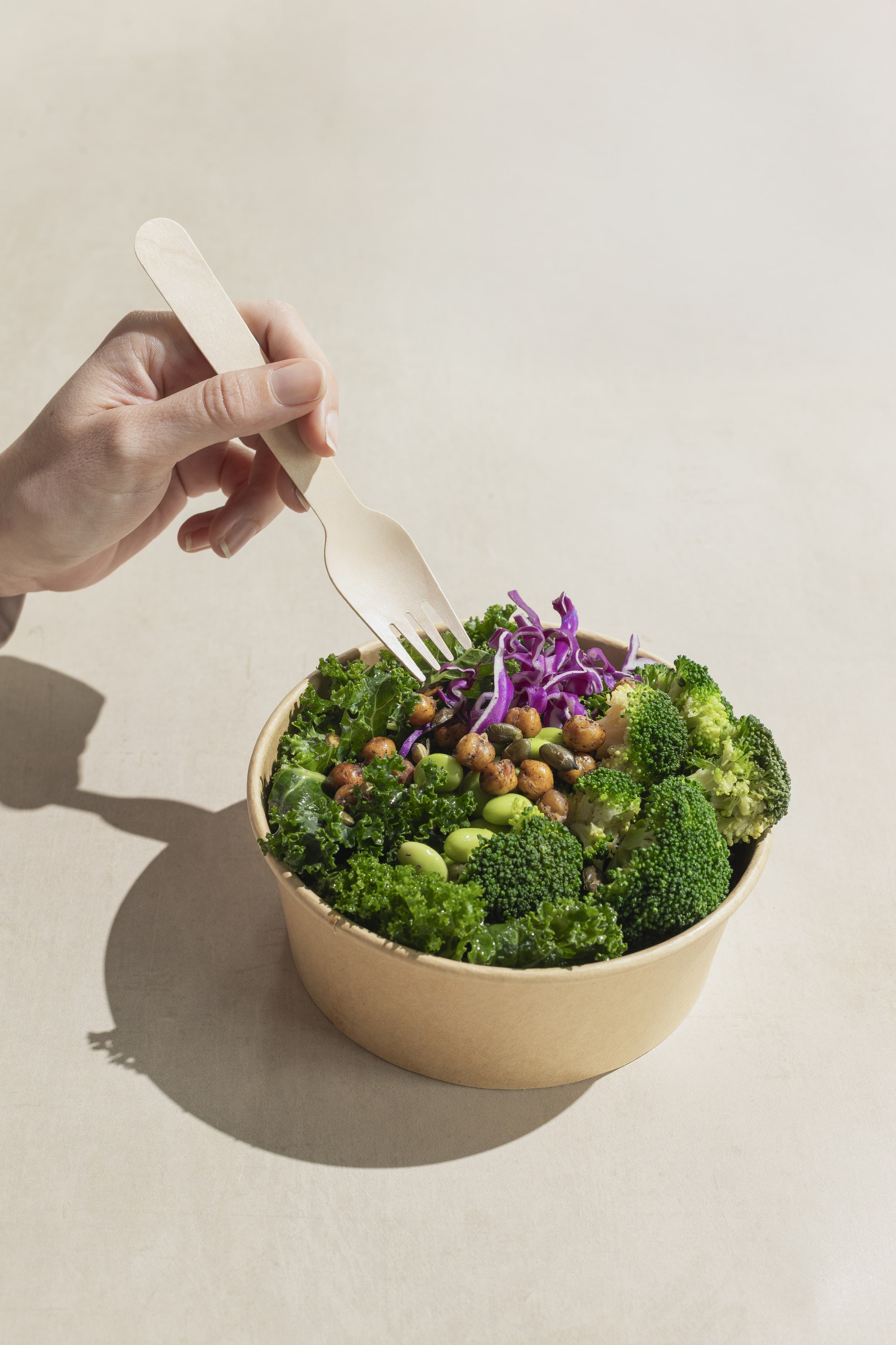 Yucca Packaging kraft salad bowl and lid packed with a green salad.